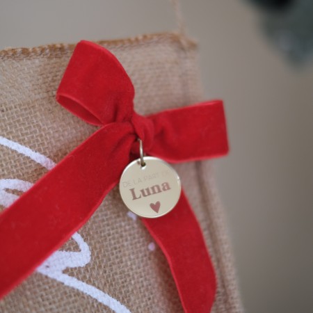 Détail du nœud rouge et du médaillon personnalisé de la chaussette Sweetie