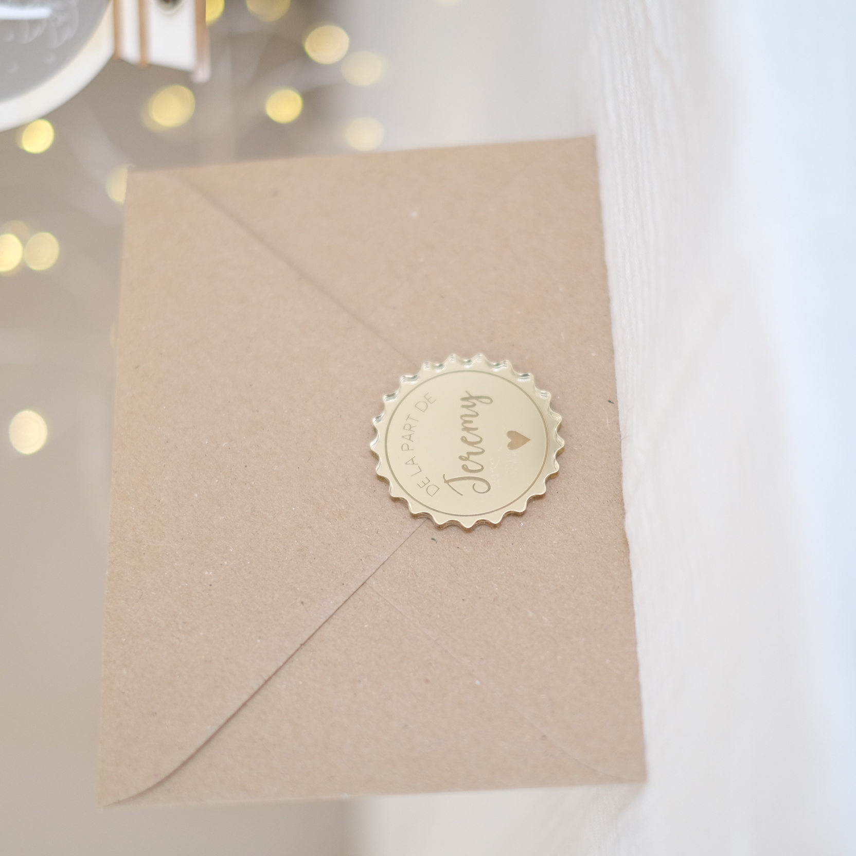 Enveloppe kraft avec sceau en plexiglas miroir doré au prénom de la personne qui offre